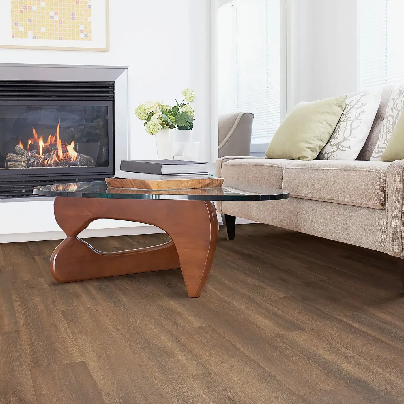 Laminate in a medium brown wood tone in a living room with a fireplace | Fantastic Floors